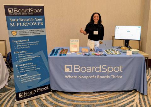 Mickey Rodriguez, Board Portal Specialist in front of the BoardSpot booth at a nonprofit conference.